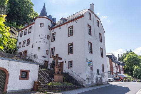 <p>Historisches Gebäude in Gerolstein mit der Aufschrift 'Anno 1710' und '1949', Treppen und Statue im Vordergrund.</p>