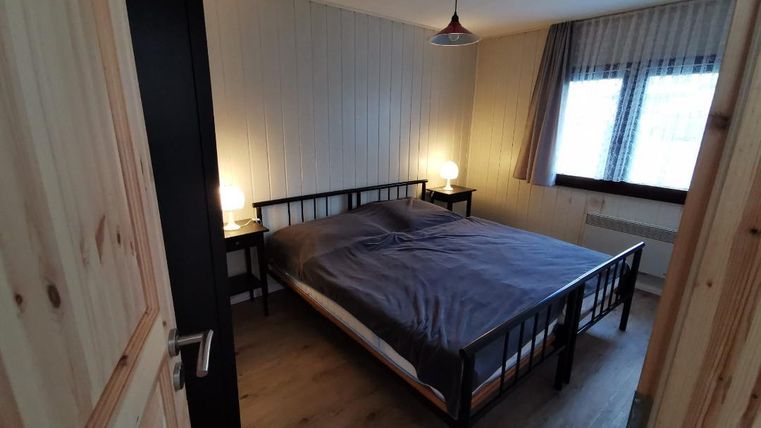 Ein gemütliches Schlafzimmer mit einem großen Bett und zwei Nachttischen. Das Licht ist warm und schafft eine einladende Atmosphäre.