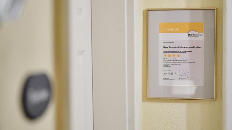 Ein eingerahmtes Zertifikat hängt an der Wand. Es zeigt eine Auszeichnung für eine Dienstleistung mit mehreren Bewertungssternen.