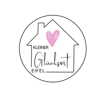 Ein runder Logo mit einem stilisierten Haus und einem Herz. Der Text enthält die Wörter "KLEINER Glücksort Eifel".