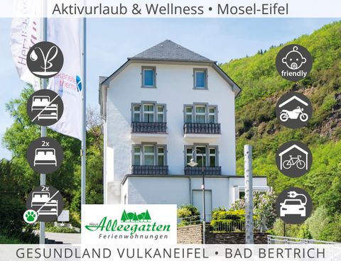 Een modern gebouw in de natuur, omgeven door groene heuvels. Het promoot activiteiten en wellness in Bad Bertrich, Mosel-Eifel.