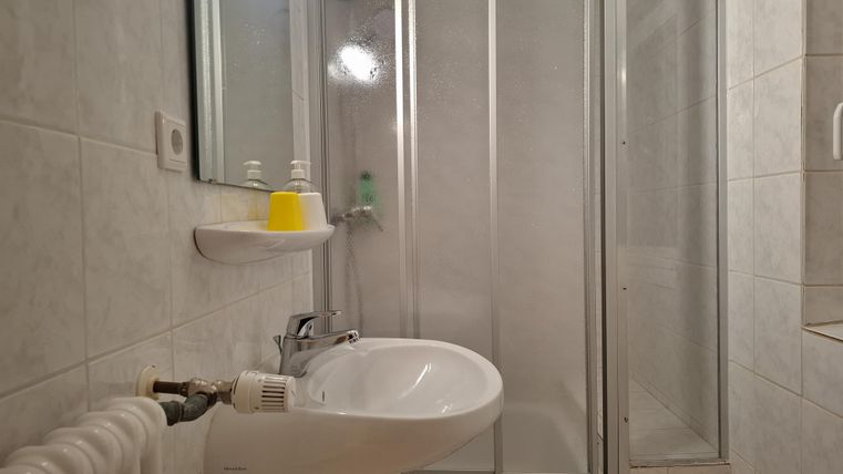 Ein kleines Badezimmer mit einer Dusche und einem Waschbecken.