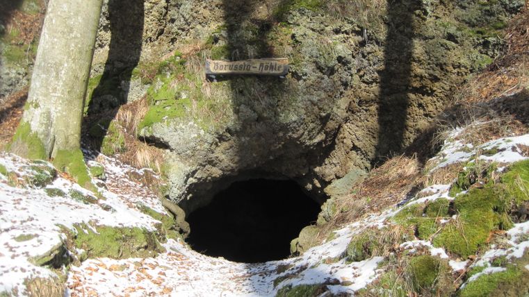 Entrance to the Borussia Cave in Hohenfels-Essingen covered in moss and snow.