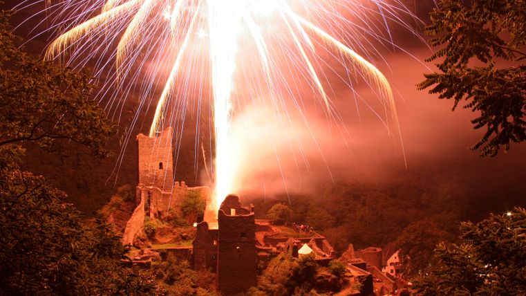 Ein beeindruckendes Feuerwerk über einer alten Ruine in der Nacht. Der Himmel ist erleuchtet und die Atmosphäre ist festlich.