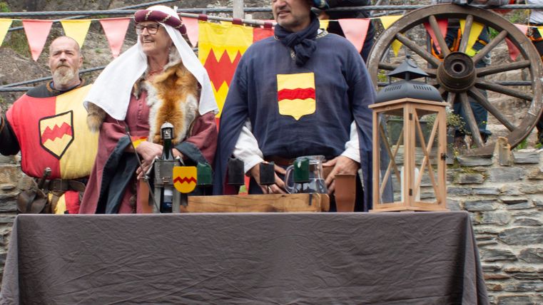 Vier personen in historische kostuum staat op een weiland. Op de achtergrond zijn bomen te zien.