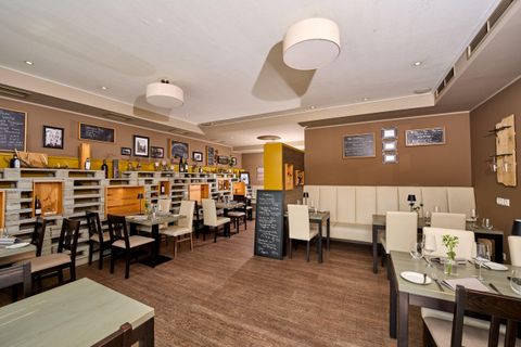 Ein modernes Restaurant mit Holzmöbeln und gemütlicher Atmosphäre. Die Wände sind mit Bildern und Tafeln dekoriert.