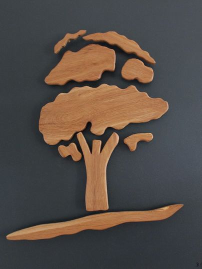 Ein kunstvoll geschnitzter Baum aus Holz auf dunklem Hintergrund. Die Form ist schlicht und modern, ideal für natürliche Ästhetik.