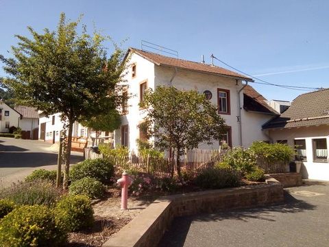 Ein hübsches Haus mit einem gepflegten Garten und Bäumen. Die Straße führt sanft bergauf und ist von weiteren Gebäuden gesäumt.