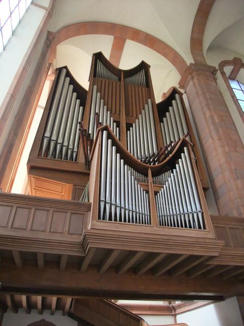 A large wooden church organ with many pipes is visible in the room. The bright interior of the church complements the impressive instrument.