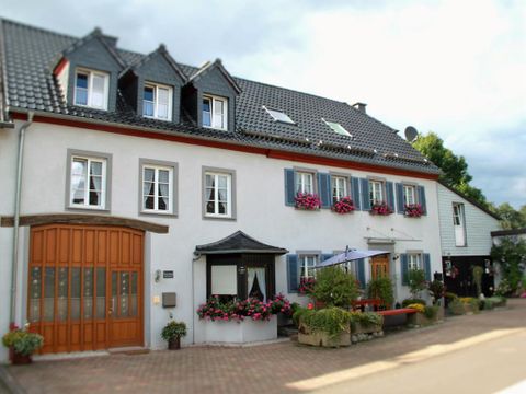 A charming house with blooming windows and a modern entrance. The garden is inviting and well-maintained.