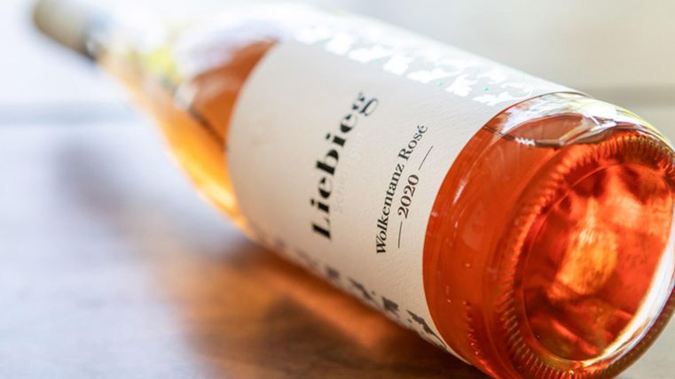 Eine Flasche Roséwein mit dem Etikett "Lieblings" liegt auf einem Tisch. Der Wein hat eine schöne, helle Farbe und stammt aus dem Jahr 2020.