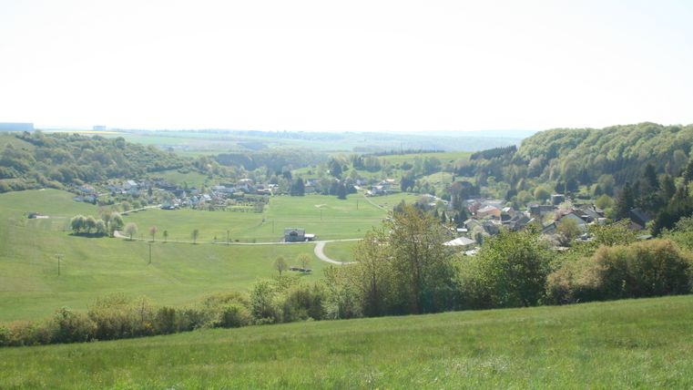 Panoramisch uitzicht op het dorp Immerath in een groen, heuvelachtig landschap.