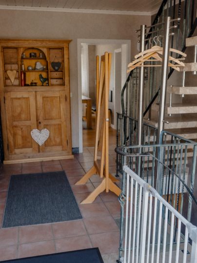 A bright hallway with a closet and a staircase.