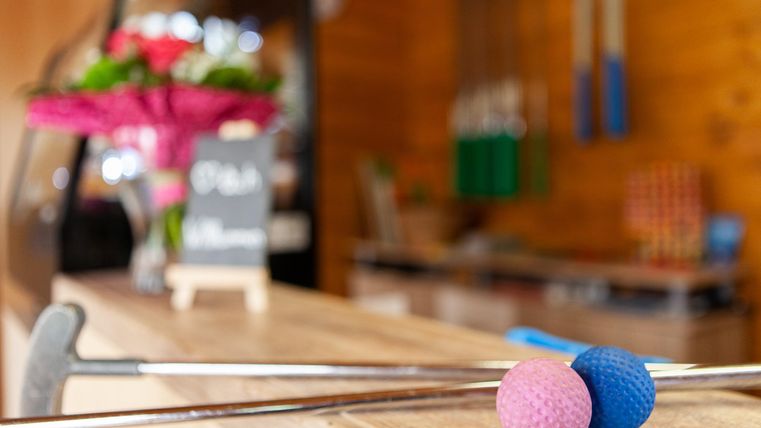 <p>Minigolf-Schläger liegen mit 2 Minigolfbällen auf einem Tresen</p>
