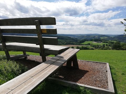 <p><p>Bild XXL Bank in Berlingen von hinten, steht auf Rindenmulch mit Landschaft und baluem Himmel im Hintergrund</p></p>