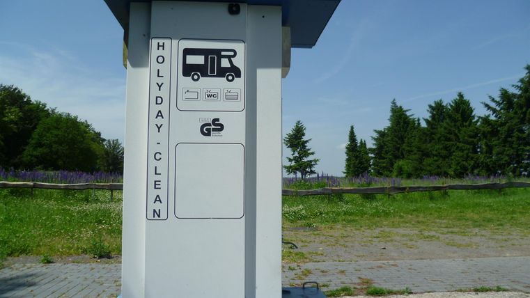 Ein Sauberkeitsstand für Wohnmobile mit einer klaren Beschilderung. Die Umgebung ist grün und offen, ideal für Reisende.