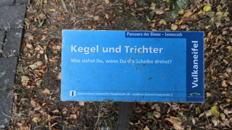 Ein Schild mit der Aufschrift "Kegel und Trichter". Es gehört zum Parcours der Sinne in der Vulkaneifel.