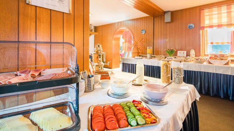 Ein reichhaltiges Frühstücksbuffet mit Aufschnitt, Käse und frischem Obst. Der Raum ist hell und einladend, ideal für einen Start in den Tag.