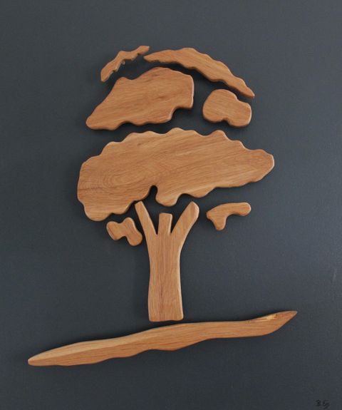 Ein kunstvoll geschnitzter Baum aus Holz auf dunklem Hintergrund. Die Form ist schlicht und modern, ideal für natürliche Ästhetik.