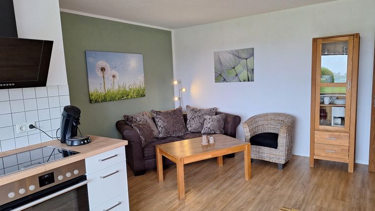 Eine gemütliche Wohnung mit einer modernen Küche und einem Wohnbereich. Der Raum ist hell und freundlich gestaltet, mit einem großzügigen Wohnzimmermöbel.