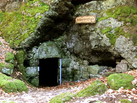 Eingang zur Schwedenfeste in einem moosbedeckten Felsen.