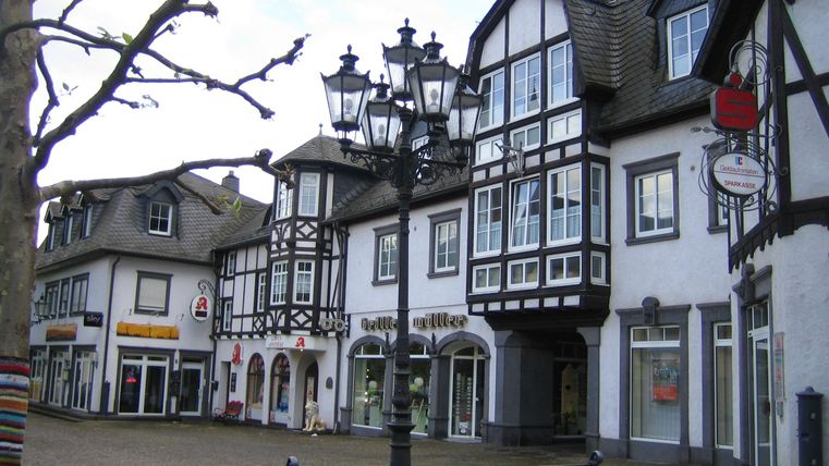 Ein malerischer Marktplatz mit Fachwerkhäusern und einer gemütlichen Bank. Die Umgebung ist ruhig und einladend.