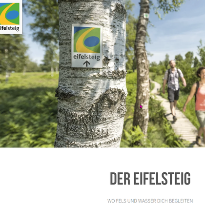 Ein Wanderweg durch eine grüne Landschaft mit einem Schild, das auf den Eifelsteig hinweist. Zwei Personen gehen entspannt den Pfad entlang.