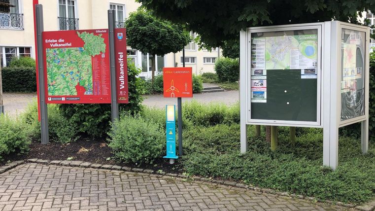 Ein Informationsbereich mit Karten zur Umgebung. Es gibt ein Schild mit Wanderwegen und einen Planständer.