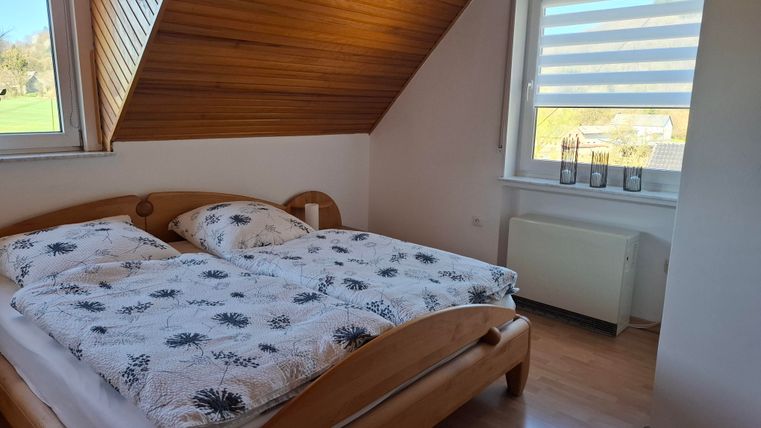 Ein gemütliches Schlafzimmer mit einem Doppelbett und Holzelementen. Das Fenster bietet einen schönen Blick auf die Umgebung.
