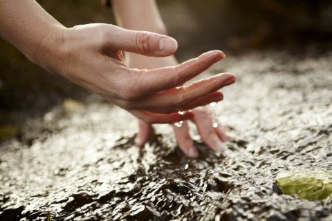 Hände berühren Wasser im Kneipp Kurort in der Vulkaneifel